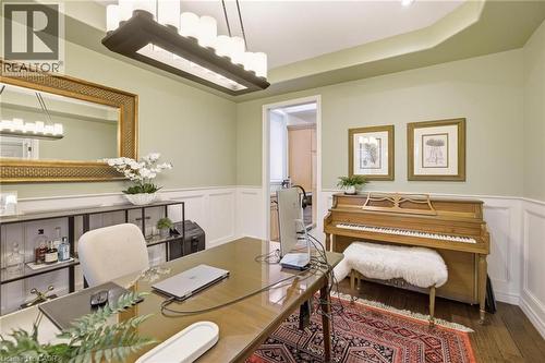 Spacious room featuring light green walls, wainscoting, recessed lighting, and a prominent rectangular chandelier - 129 Magnificent Way, Binbrook, ON - Indoor