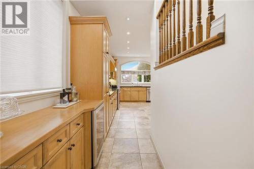Hallway featuring light wood-finish cabinetry, integrated beverage cooler, recessed lighting, and tile flooring - 129 Magnificent Way, Binbrook, ON - Indoor Photo Showing Other Room