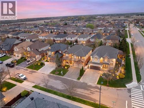 Residential streetscape featuring numerous detached homes with varied architectural styles - 129 Magnificent Way, Binbrook, ON - Outdoor With View