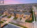 Residential streetscape featuring numerous detached homes with varied architectural styles - 129 Magnificent Way, Binbrook, ON  - Outdoor With View 