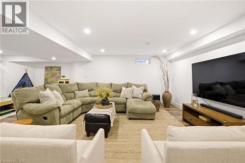 Recessed lighting illuminates this open room with wood-finish flooring and a large area rug - 129 Magnificent Way, Binbrook, ON - Indoor Photo Showing Living Room