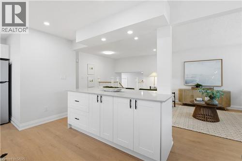 Kitchen island featuring white shaker cabinetry, matte black hardware, and a light-toned countertop - 11 Marcella Crescent, Hamilton, ON - Indoor Photo Showing Other Room