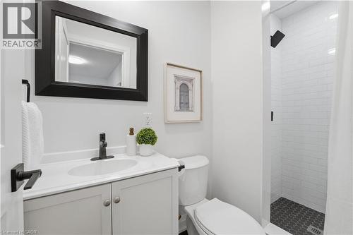 Modern bathroom featuring a white vanity with integrated sink, matte black faucet, and a framed mirror - 11 Marcella Crescent, Hamilton, ON - Indoor Photo Showing Bathroom