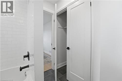 Tub and shower combination featuring subway tile surround and matte black fixtures - 11 Marcella Crescent, Hamilton, ON - Indoor Photo Showing Other Room