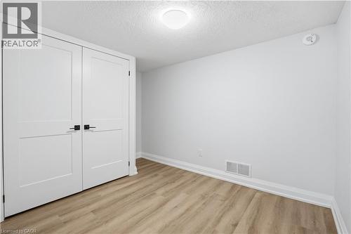 Neutral wall color complemented by wood-finish flooring - 11 Marcella Crescent, Hamilton, ON - Indoor Photo Showing Other Room