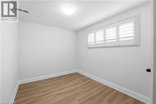 Room featuring wood-finish flooring, white baseboards, and white walls - 11 Marcella Crescent, Hamilton, ON - Indoor Photo Showing Other Room