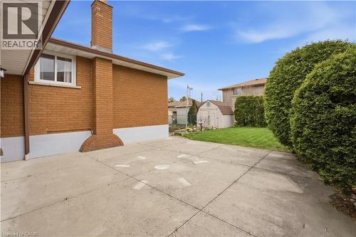 Concrete patio area with a brick exterior and a prominent chimney feature - 11 Marcella Crescent, Hamilton, ON - Outdoor