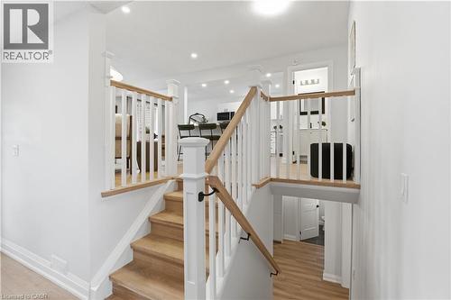Split-level entry featuring wood-finish stairs and white railings with wood-finish handrails - 11 Marcella Crescent, Hamilton, ON - Indoor Photo Showing Other Room
