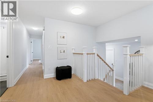 Upper-level landing featuring light wood-finish flooring, white walls, and a staircase with white spindles and light wood-finish handrails - 11 Marcella Crescent, Hamilton, ON - Indoor Photo Showing Other Room