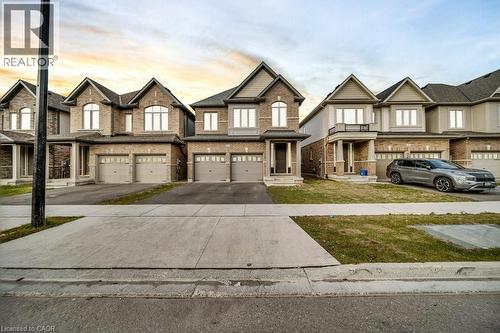 View of front of house featuring driveway, brick siding, an attached garage, and a yard - 285 Broadacre Drive, Kitchener, ON - Outdoor With Facade