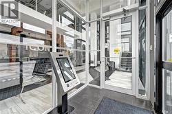 Lobby entrance featuring expansive glass panels and a digital directory kiosk - 