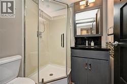 Modern bathroom featuring a glass-enclosed corner shower with a white base - 