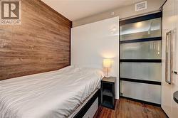 Compact living area featuring wood-finish flooring and a decorative wood-paneled accent wall - 