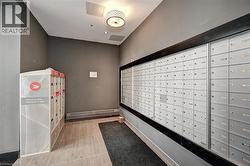 Mailroom featuring extensive wall-mounted mailboxes and a dedicated parcel locker system - 