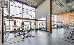 Fitness center featuring floor-to-ceiling windows, exposed structural beams, and wood-paneled walls - 