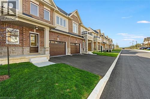 Brick facade with stone accents, an attached garage, and a covered porch entry - 205 Thames Way Unit# 31, Hamilton, ON - Outdoor