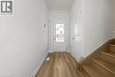 Entryway featuring wood-finish flooring, white baseboards, a white paneled door, and a wooden staircase - 205 Thames Way Unit# 31, Hamilton, ON  - Indoor Photo Showing Other Room 
