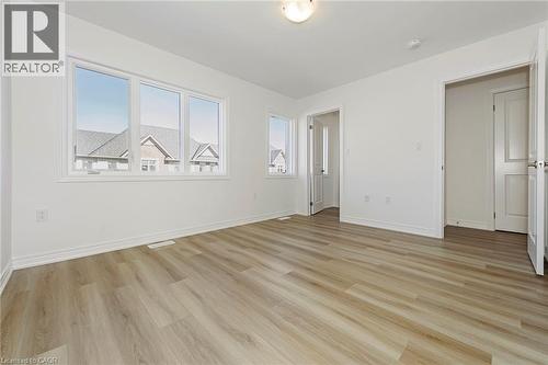 Spacious room featuring light wood-finish flooring, white baseboards, and a large triple window with white trim - 205 Thames Way Unit# 31, Hamilton, ON - Indoor Photo Showing Other Room