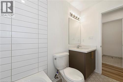 Bathroom featuring white subway tile, a dark wood-finish vanity with quartz counters and Euro-style tile floors - 205 Thames Way Unit# 31, Hamilton, ON - Indoor Photo Showing Bathroom
