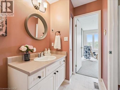Bathroom featuring a single vanity with a laminate countertop, integrated sink, and chrome faucet - 245 Bishop Street S Unit# 4, Cambridge, ON - Indoor Photo Showing Bathroom