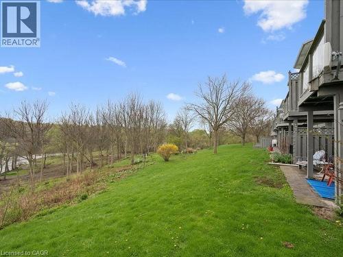 Expansive green space featuring a sloped lawn and mature trees - 245 Bishop Street S Unit# 4, Cambridge, ON - Outdoor