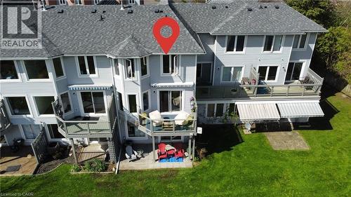 Rear exterior featuring multiple balconies, a ground-level patio, and a manicured lawn - 245 Bishop Street S Unit# 4, Cambridge, ON - Outdoor