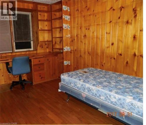 Wood-paneled interior featuring built-in shelving, an integrated desk, and coordinating wood-finish flooring - 134 Greenbrier Drive, Waterloo, ON - Indoor Photo Showing Bedroom