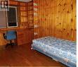 Wood-paneled interior featuring built-in shelving, an integrated desk, and coordinating wood-finish flooring - 134 Greenbrier Drive, Waterloo, ON  - Indoor Photo Showing Bedroom 