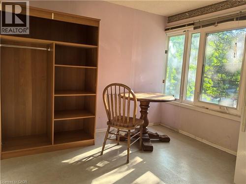 Room featuring light-colored walls and flooring, a multi-pane window, and a built-in wood-finish shelving unit with an integrated wardrobe rod - 134 Greenbrier Drive, Waterloo, ON - Indoor