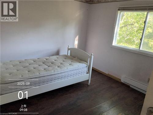 Room featuring wood-finish flooring, white walls, and a large window with white trim - 134 Greenbrier Drive, Waterloo, ON - Indoor Photo Showing Bedroom