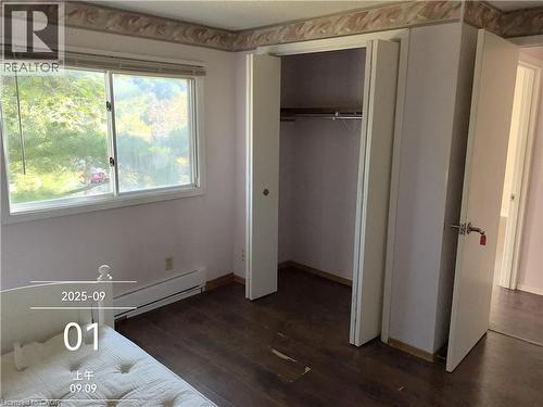 Room featuring wood-finish flooring, a double window, and a built-in closet with bi-fold doors - 134 Greenbrier Drive, Waterloo, ON - Indoor Photo Showing Other Room
