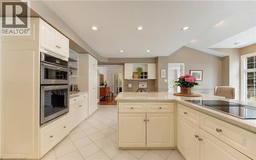 Kitchen featuring light cabinetry, integrated double ovens, an island with an integrated cooktop, recessed lighting, and tiled flooring - 514 Colonial Drive, Waterloo, ON - Indoor Photo Showing Kitchen