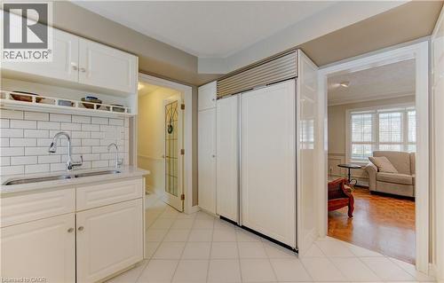 Kitchen featuring white cabinetry, subway tile backsplash, and a double-door paneled refrigerator - 514 Colonial Drive, Waterloo, ON - Indoor Photo Showing Kitchen With Double Sink