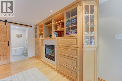 Custom built-in cabinetry and shelving with an integrated fireplace and glass-front display cabinets - 514 Colonial Drive, Waterloo, ON - Indoor With Fireplace