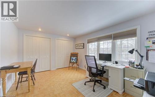 Bright room with light wood-finish flooring, featuring two sets of bi-fold closet doors, recessed lighting, and a triple window with window treatments - 514 Colonial Drive, Waterloo, ON - Indoor Photo Showing Office
