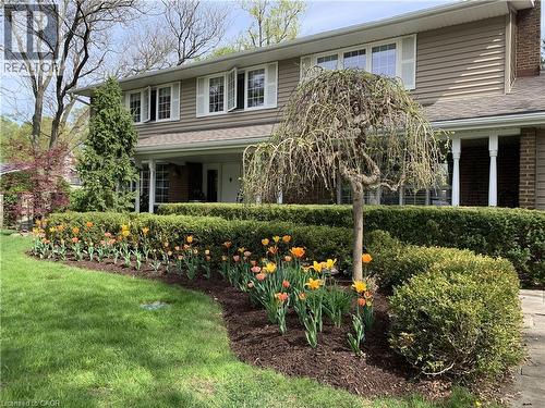 Two-story residence featuring horizontal siding, white window shutters, and a covered entry with white columns - 514 Colonial Drive, Waterloo, ON - Outdoor