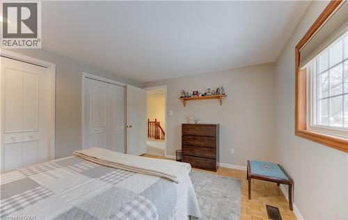 Bedroom featuring two bi-fold closet doors and wood-finish flooring - 514 Colonial Drive, Waterloo, ON - Indoor Photo Showing Bedroom