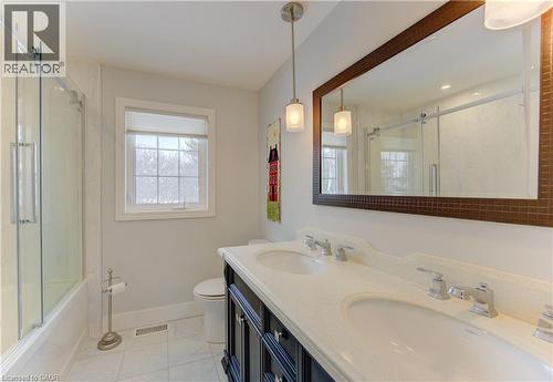 Bathroom featuring a double vanity with integrated sinks, a large framed mirror, and pendant lighting - 514 Colonial Drive, Waterloo, ON - Indoor Photo Showing Bathroom
