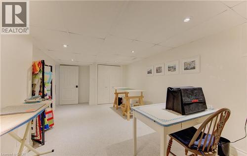 Finished lower level featuring recessed lighting, light-toned carpeting, two white paneled doors, and a drop ceiling - 514 Colonial Drive, Waterloo, ON - Indoor