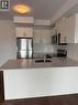 Kitchen featuring dark wood-style flooring, a peninsula, appliances with stainless steel finishes, a sink, and backsplash - 1000 Lackner Place Unit# 401, Kitchener, ON  - Indoor Photo Showing Kitchen 