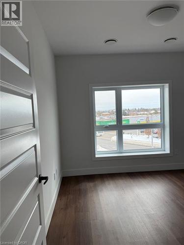 Spare room featuring baseboards and dark wood-type flooring - 1000 Lackner Place Unit# 401, Kitchener, ON - Indoor Photo Showing Other Room