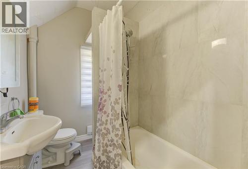 Bathroom featuring shower / bath combination with curtain, vanity, vaulted ceiling, and wood finished floors - 138 Courtland Avenue E, Kitchener, ON - Indoor Photo Showing Bathroom