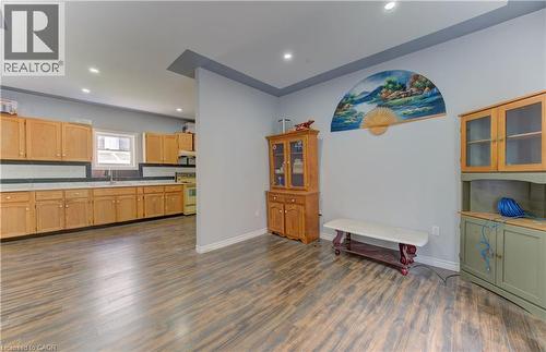 Kitchen with glass insert cabinets, recessed lighting, light countertops, dark wood-style flooring, and white range with electric stovetop - 138 Courtland Avenue E, Kitchener, ON - Indoor Photo Showing Other Room