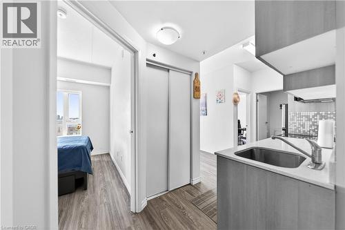Compact kitchen featuring wood-finish cabinetry, a stainless steel undermount sink, and a light-colored countertop - 246 Lester Street Unit# Ph-03, Waterloo, ON - Indoor Photo Showing Kitchen