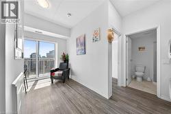 Living area featuring wood-finish flooring and a glass sliding door opening to a balcony - 