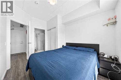 Bedroom featuring wood-finish flooring, a built-in closet with sliding doors, and a ceiling-mounted light fixture - 246 Lester Street Unit# Ph-03, Waterloo, ON - Indoor Photo Showing Bedroom