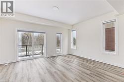 Spacious interior with wood-finish flooring, white walls, and a recessed ceiling light - 