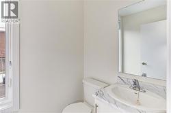 Bathroom featuring a marble-finish vanity with an integrated sink, polished chrome faucet, and a large wall-mounted mirror - 