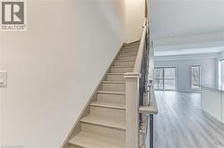 Staircase with light wood-finish treads and handrail - 