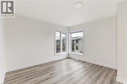 Neutral paint colors throughout, wood-finish flooring, white baseboards, and a contemporary ceiling light fixture - 
